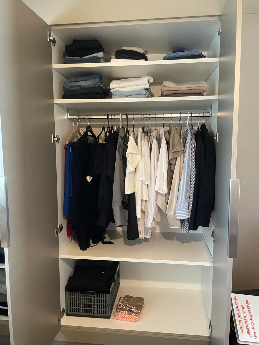 Offener grosser Kleiderschrank, Fächer aufgeräumt.